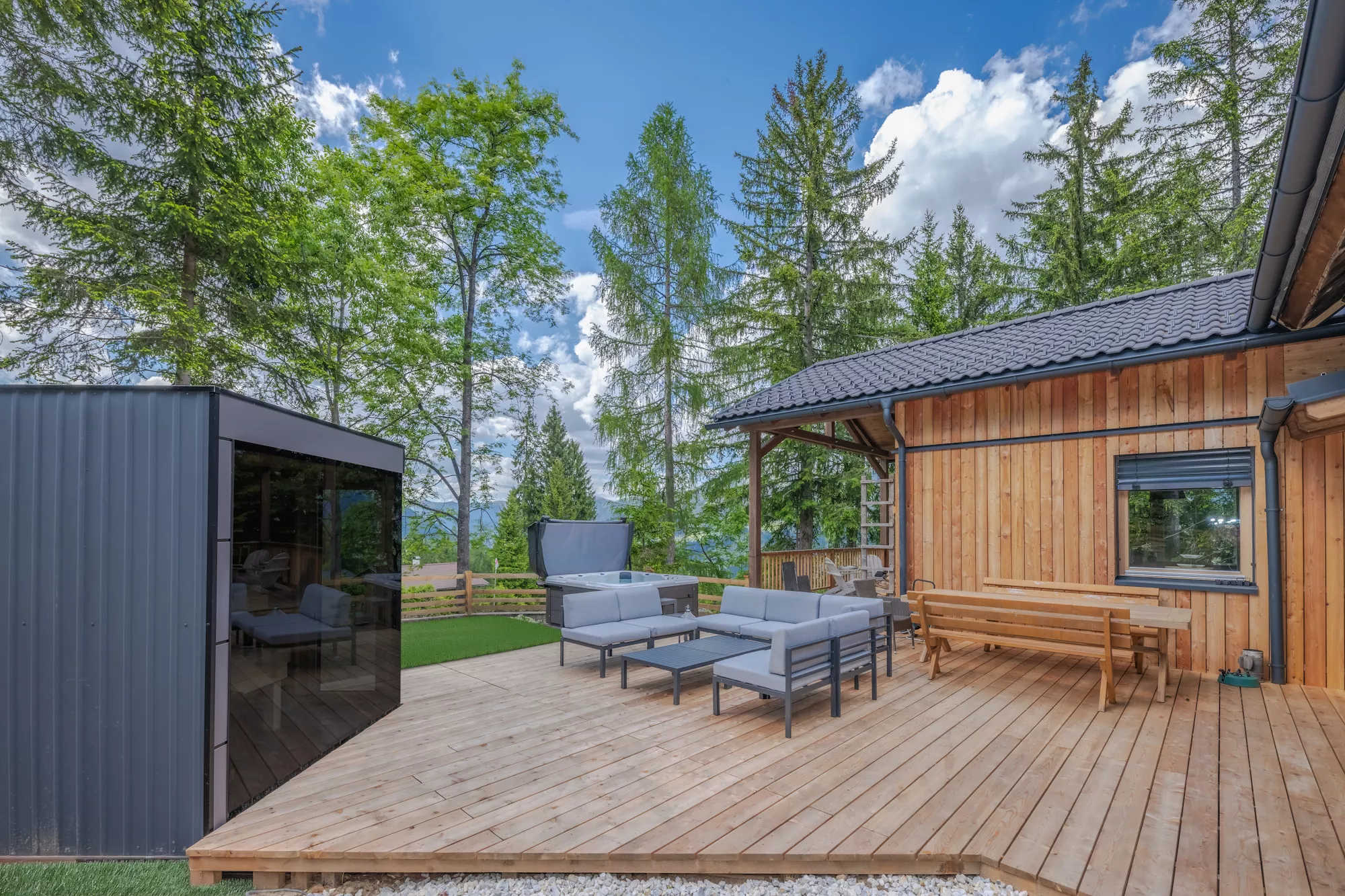 Außenansicht der Terrasse mit Saune, Whirlpool, Loungebereich und Essgruppe Außenansicht der Terrasse mit Saune, Whirlpool, Loungebereich und Essgruppe